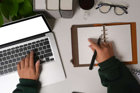 Above view man holding coffee cup and typing on wireless keyboard.の写真素材