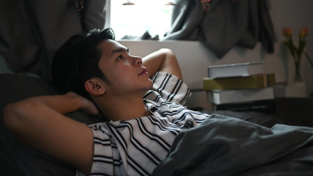 Young man laying on his bed