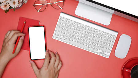Mock up mobile phone, coffee cup and computer on red background.の写真素材