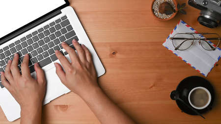 Photographer workplace with laptop computer, coffee cup and camera on wooden desk.の写真素材