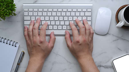 Man hands typing on wireless keyboard over his workspace.の写真素材