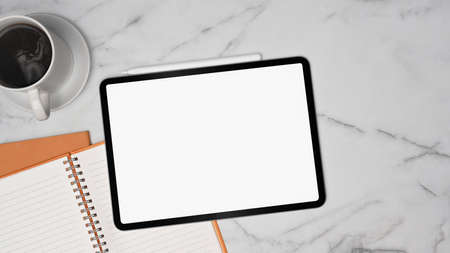Above view digital tablet, notebook and coffee cup on marble background.の写真素材