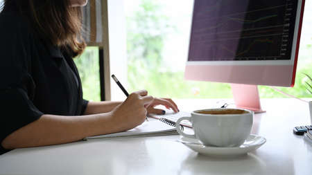 Businesswoman checking stock market on desktop computer.の写真素材