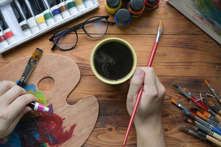 Male artist holding painting brush and mixing color on palette.の写真素材
