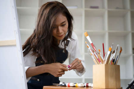 Creative Asian woman working with digital tablet at art studio.の写真素材