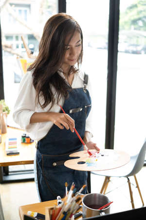 Creative Asian woman working with digital tablet at art studio.の写真素材