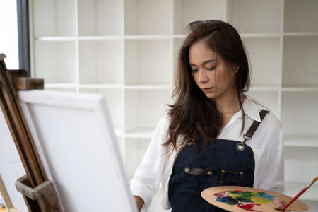 Cropped shot female designer holding stylus pen and drawing on digital tablet.の写真素材