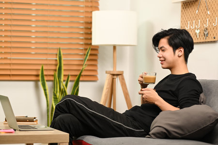 Asian man using computer tablet in living room.の写真素材