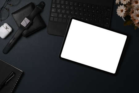 Above view dark modern workspace with digital tablet, laptop computer and smart phone on black...