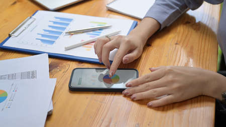 Businesswoman analyzing business data on smart phone.の写真素材