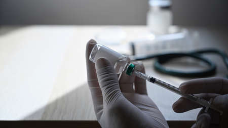 Close up doctor holding syringe and bottle of vaccine. Healthcare and Medical concept.の写真素材