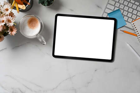 Mock up digital tablet, coffee cup and notepad on marble table.