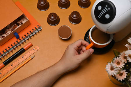 Man making hot coffee with coffee machine on brown leather.の写真素材