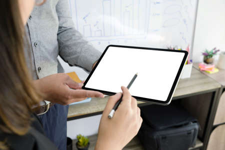 Cropped shot businesswoman holding digital tablet and sharing  ideas with her colleague.の写真素材