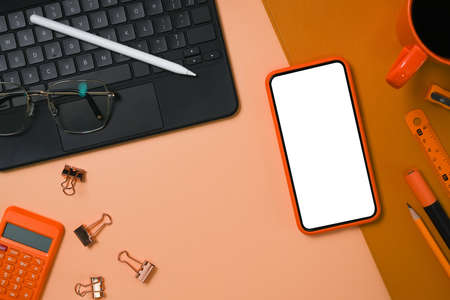 Above view smart phone, calculator, computer laptop and stationery on beige background.の写真素材