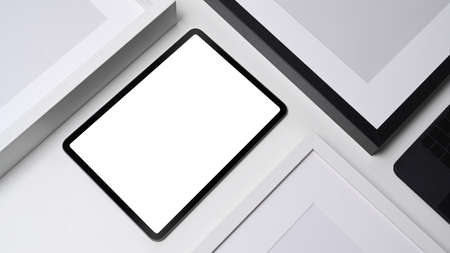 Flat lay, mock up digital tablet and empty picture frames on white background.の写真素材