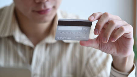 Young Asian man holding credit card for banking online or shopping online.