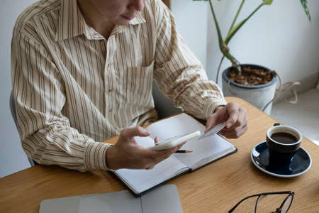 Cropped shot man using smart phone and holding credit card.の写真素材