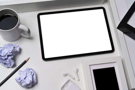 Mock up digital tablet, crumpled paper and coffee cup on white table.の写真素材