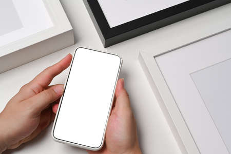 Close up view man holding smart phone with blank display.の写真素材