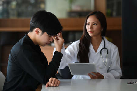 Female doctor giving consultation and advice to her depressed patient at the hospital.の写真素材