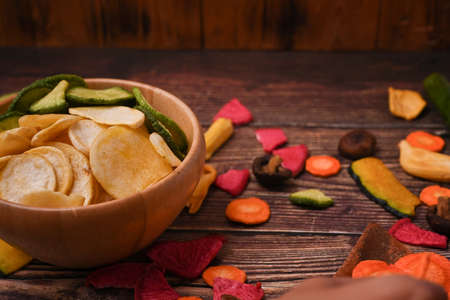 Healthy homemade vegetable chips on wooden background.の写真素材