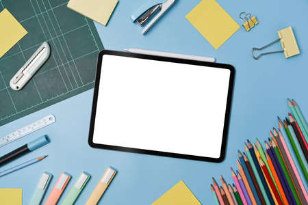 Mock up digital tablet with empty display and school stationery on blue background. Back to school...