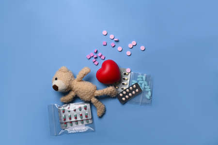 Teddy bear and medical pills on blue background.の写真素材