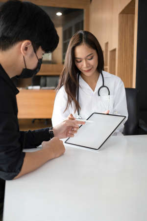 Female doctor showing and explaining medical result on digital tablet to her patient.の写真素材