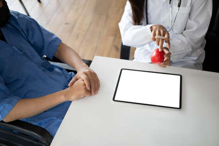 Female doctor showing and explaining medical result on digital tablet to her patient.