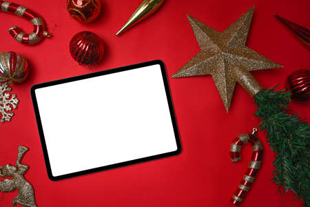 Christmas holiday celebration concept. Digital with Christmas decorations on white and red background.の写真素材