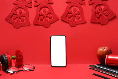 Smart phone with Christmas decorations on red background. Christmas and New year concept.の写真素材