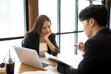 Two business colleagues working on new project together in office.の写真素材