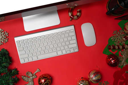 Computer on red background with Christmas decorations.の写真素材