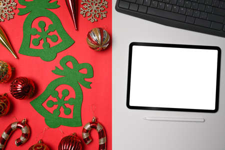 Mock up digital tablet with Christmas decorations on white and red background.の写真素材