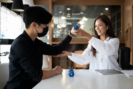 Female physiotherapist doing therapeutic exercises for patient.の写真素材