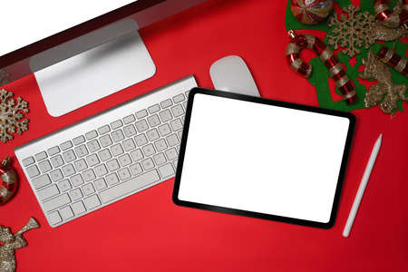 Computer and digital tablet with Christmas decorations on red background.の写真素材