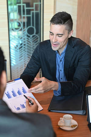 Confident executive businessman holding digital tablet and presentation financial information in...