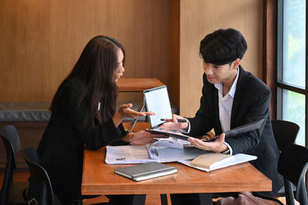 Two business office workers working on project together in office.の写真素材