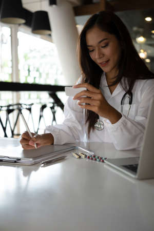 Charming female doctor in medical uniform working in medical clinic.の写真素材