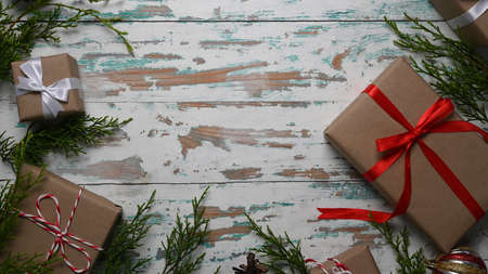 Gifts, fir tree branches, red decorations on wooden background. Flat lay, top view, copy space.の写真素材