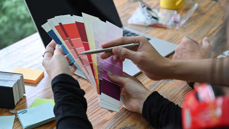 Team of creative designer choosing colors from palette guide for their new project.の写真素材