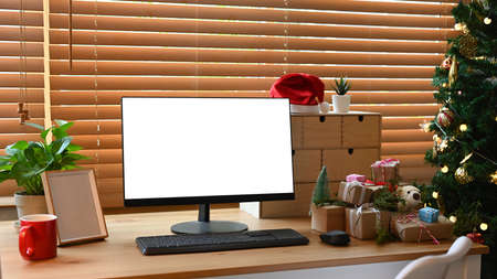 Christmas gift boxes on wooden table near the Christmas tree in living room.の写真素材
