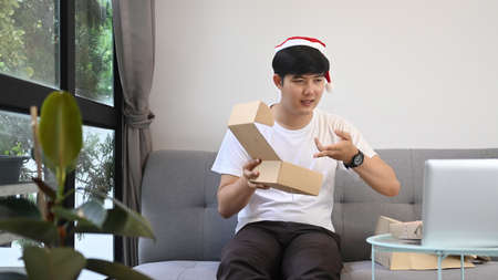 Young Asian man drinking coffee and having video call with family.の写真素材