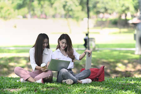 Two young business people working with digital tablet together in the park.の写真素材