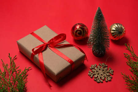 Cup of hot coffee and Christmas gift boxes on red background.