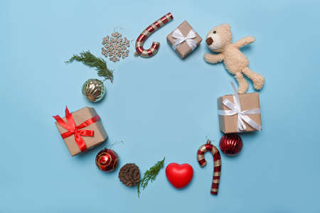 Santa hat, Christmas gifts, pine cone and fir tree branches on blue background.の写真素材