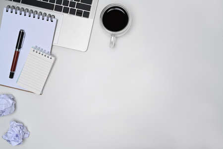 Mock up computer laptop, notebooks and coffee cup on white office desk.