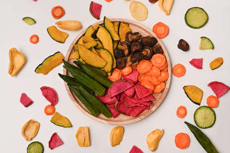 Colorful mix vegetable chips with okra, carrots, pumpkin, beetroot and shiitake mushrooms on white background.の写真素材