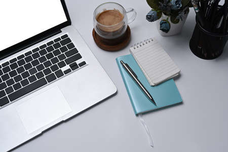 Mock up computer laptop, notebooks and coffee cup on white office desk.の写真素材